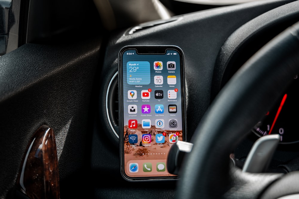 black iphone 4 on car dashboard