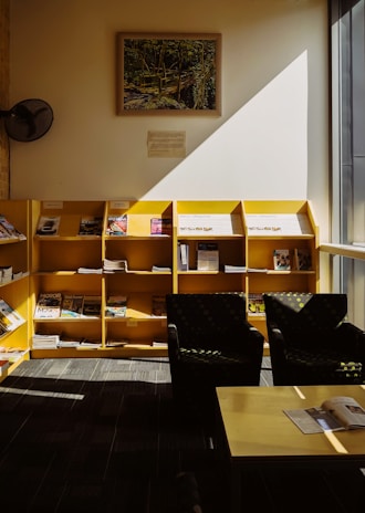 A cozy reading nook with a stack of the latest elbarriousacon/safo tabloids on a wooden table.