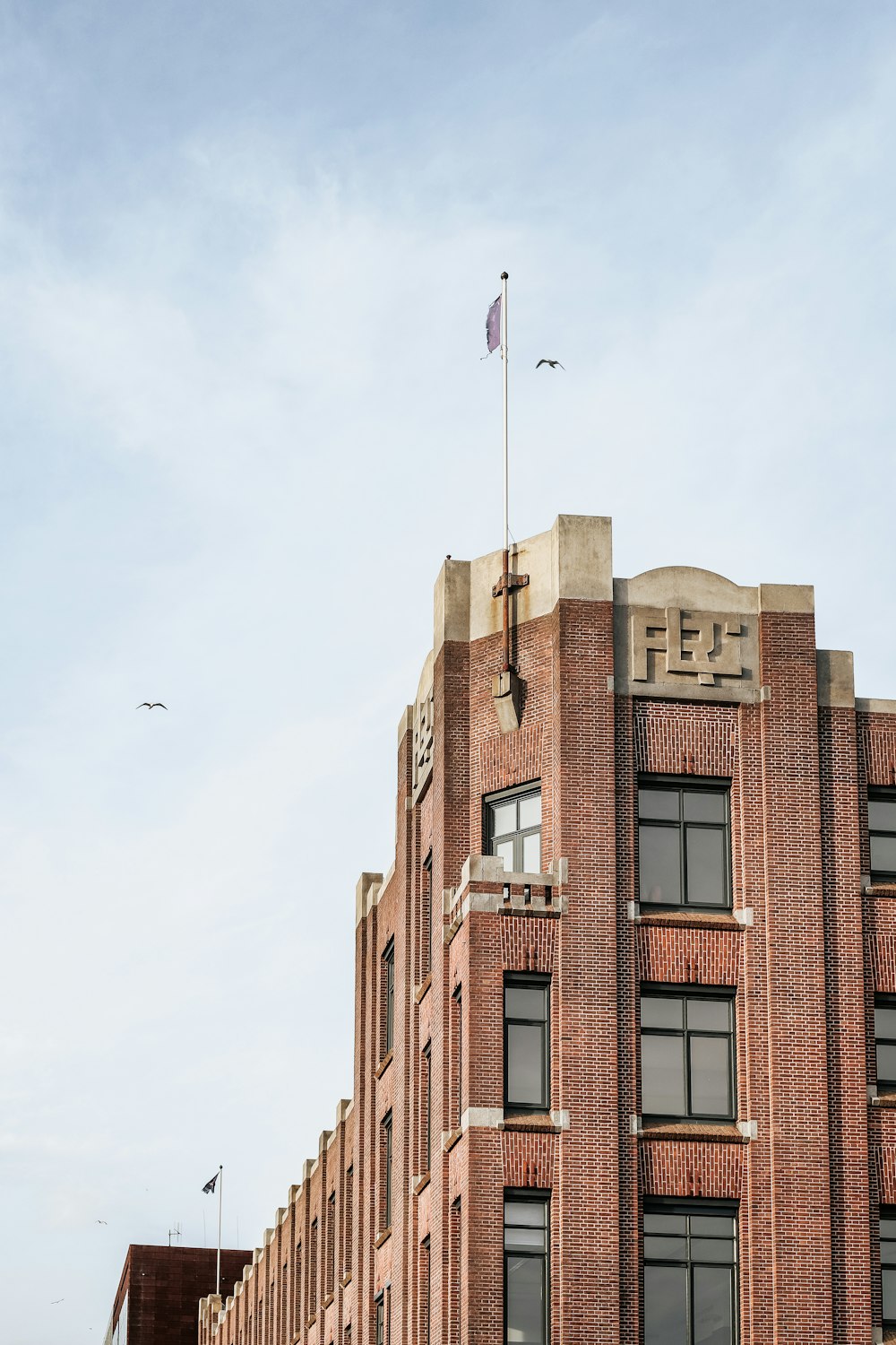 Edificio de hormigón marrón con bandera blanca en la parte superior