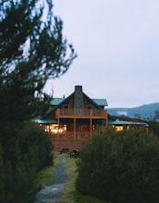brown wooden house near green trees during daytime
