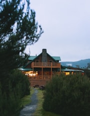brown wooden house near green trees during daytime