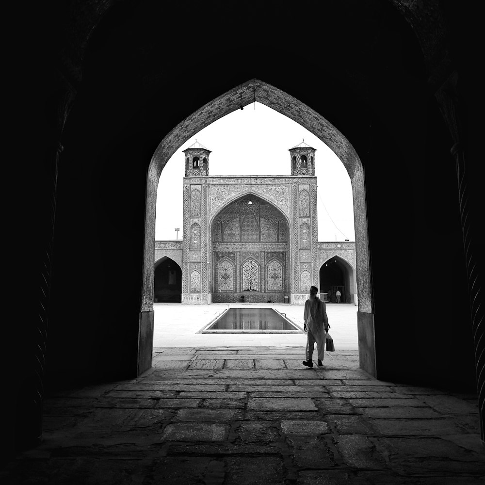 man in black suit walking on hallway