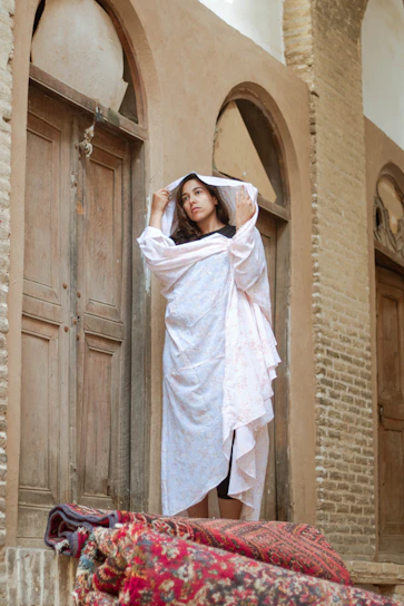 A vibrant Moroccan djellaba hanging on a rustic wooden door under soft sunlight.