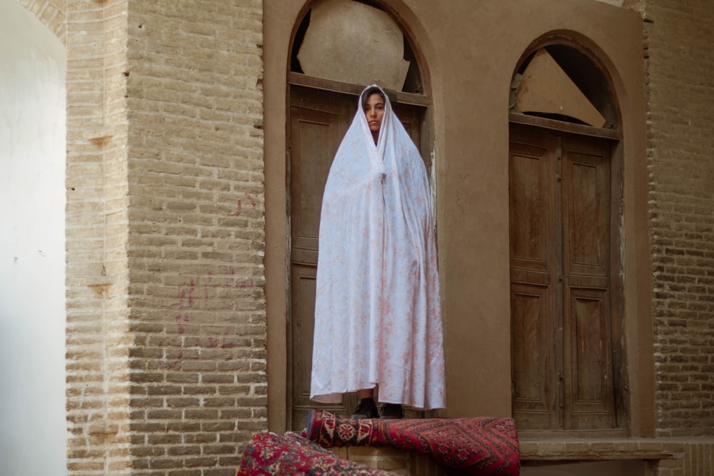 white robe hanged on brown wooden door