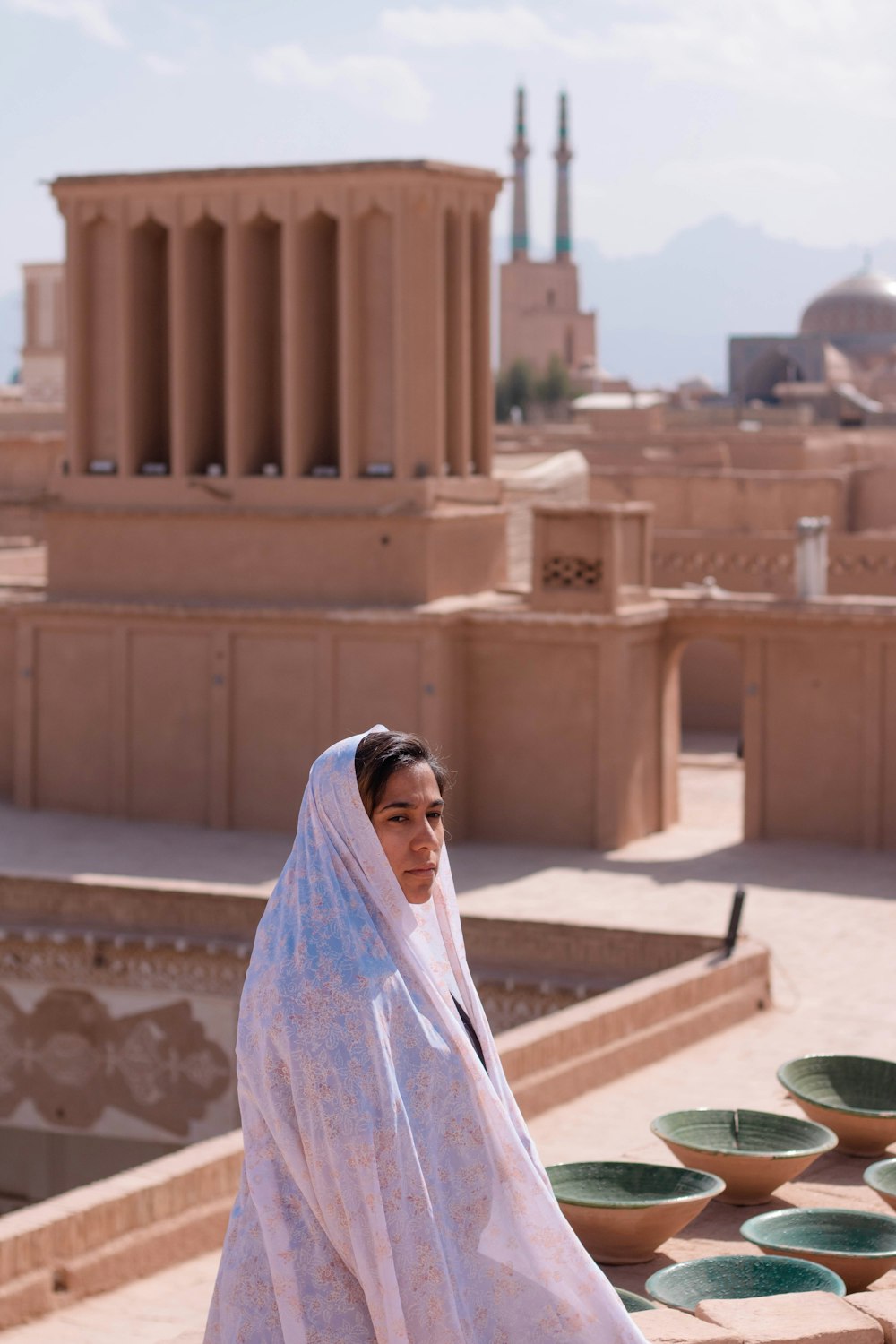 woman in white and purple hijab standing on brown concrete building during daytime