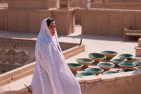 A woman on a rooftop above the old city — Yazd, Iran
