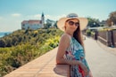 woman in blue and white floral halter top sitting on brown wooden dock during daytime