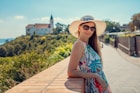 woman in blue and white floral halter top sitting on brown wooden dock during daytime