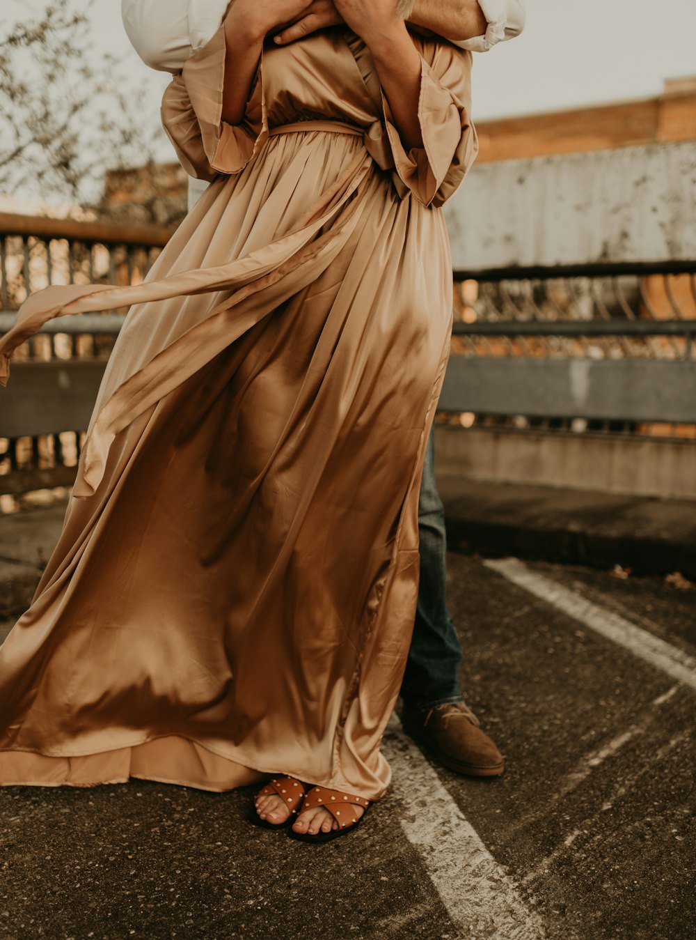 woman in brown dress standing on the road