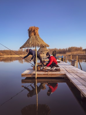 Fishing buddies untangling lines and sharing tips on a sunny dock.