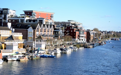 blue and white boat on water near houses during daytime