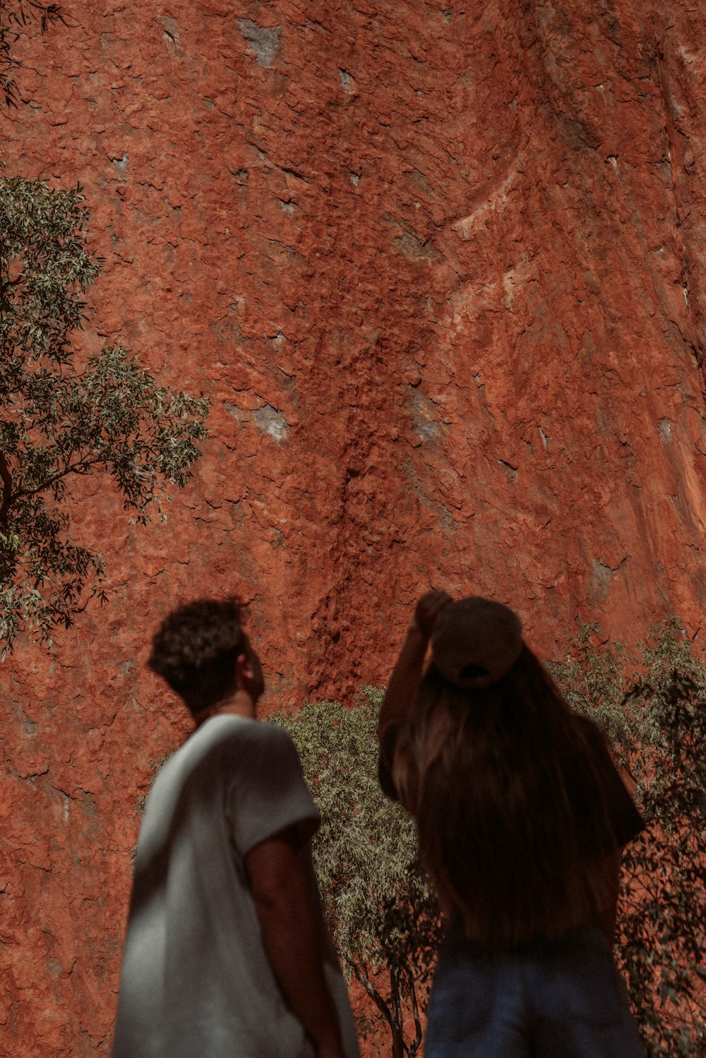 昼間、茶色の岩層のそばに立つ男女