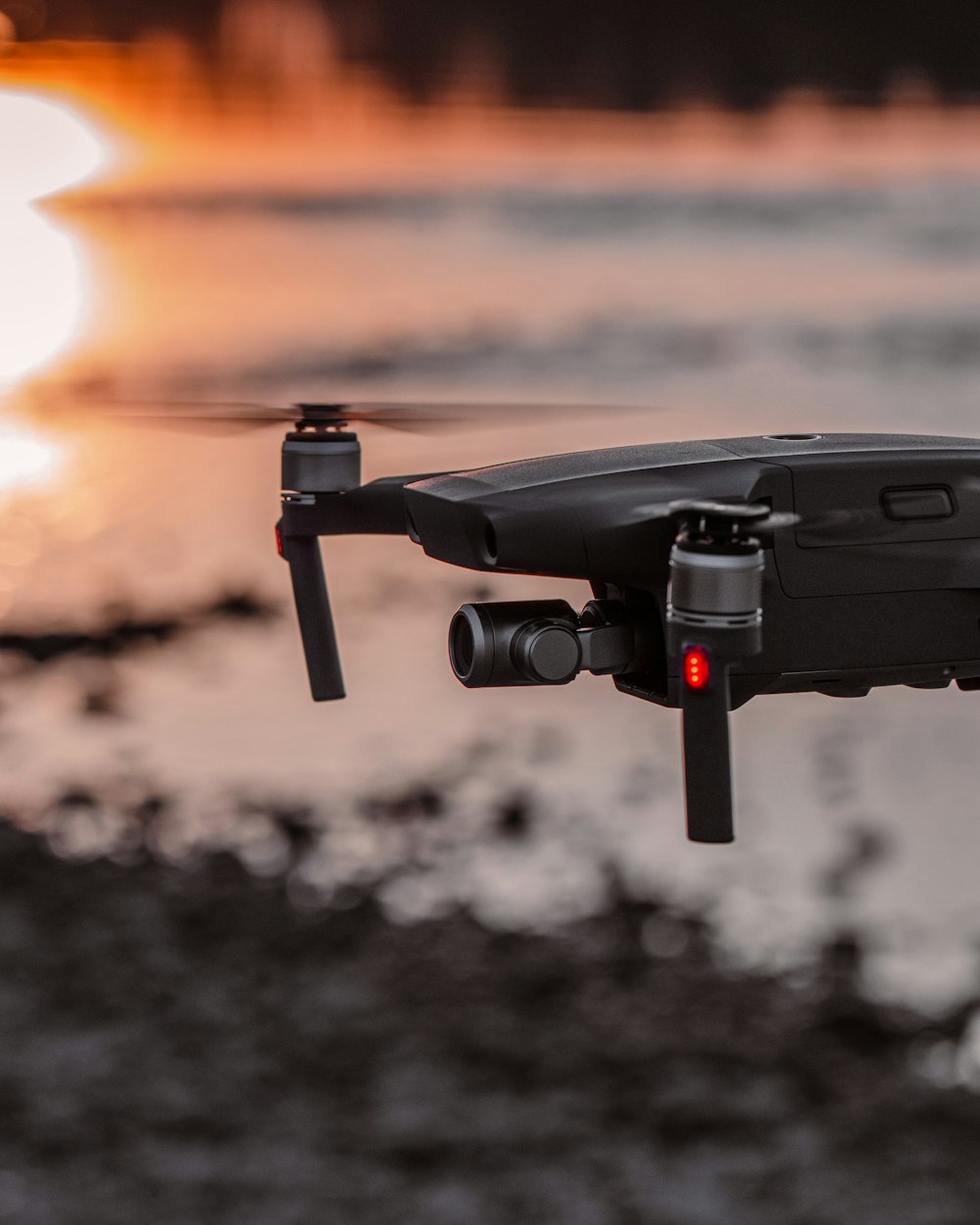 Schwarz-graue Drohne in der Luft während des Sonnenuntergangs