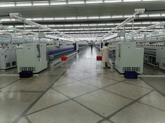 Photo of Strapright’s manufacturing floor with workers operating strapping machinery.