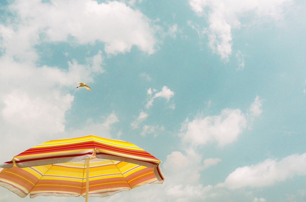 yellow and white umbrella under blue sky during daytime