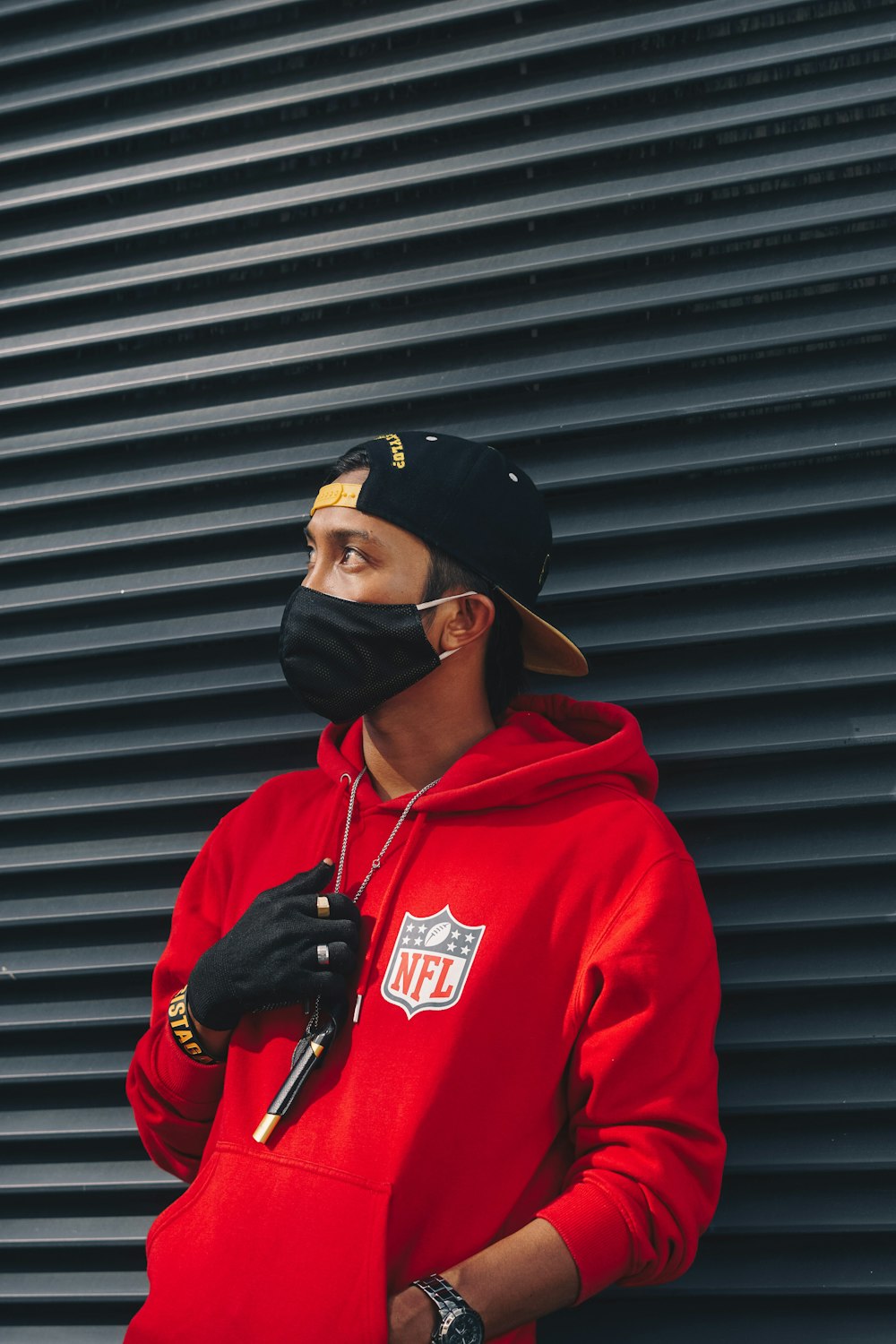 man in red hoodie wearing black cap