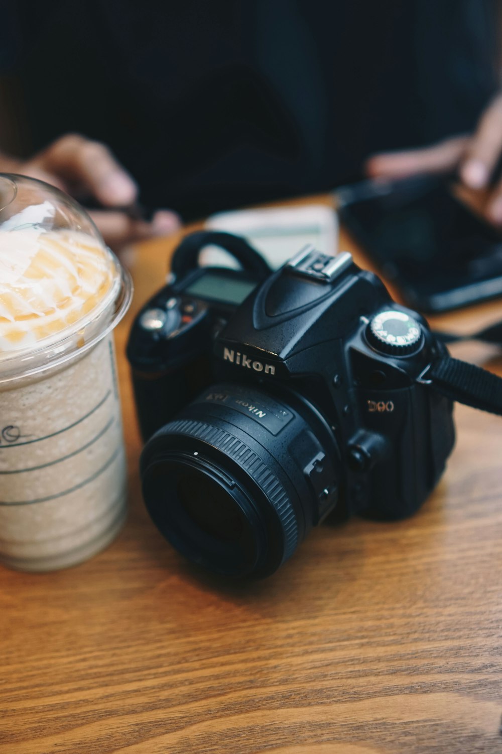 black nikon dslr camera on brown wooden table