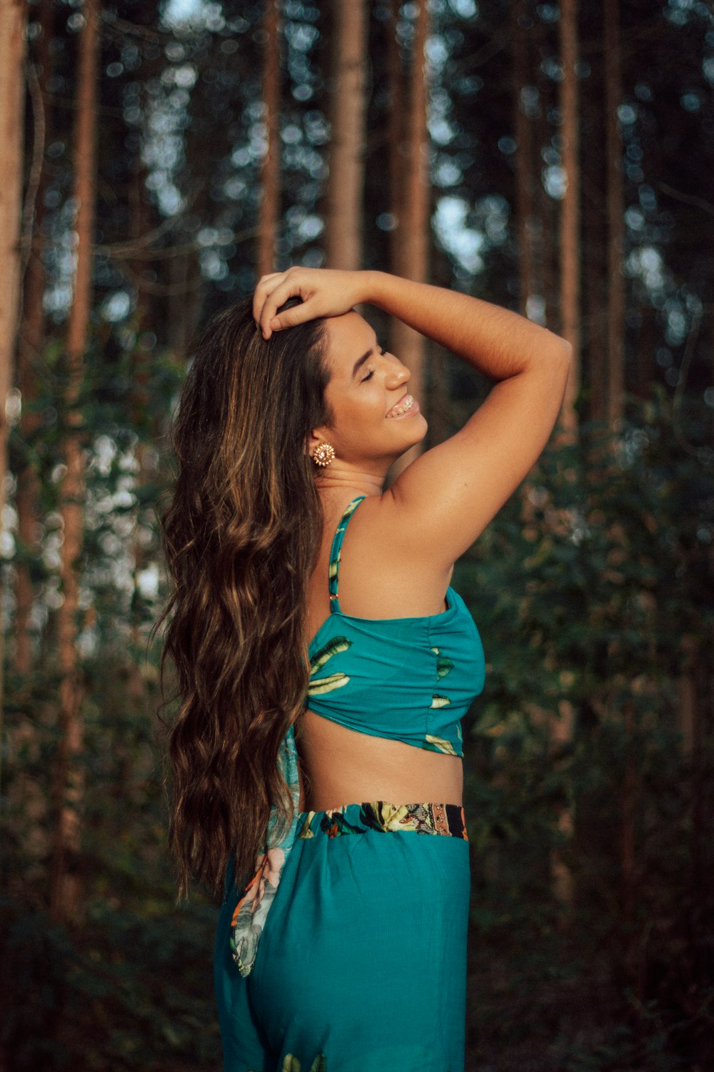 woman in blue bikini top raising her hands