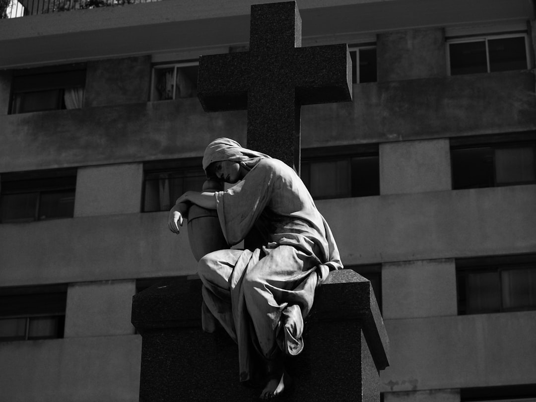 man in gray jacket sitting on black concrete bench