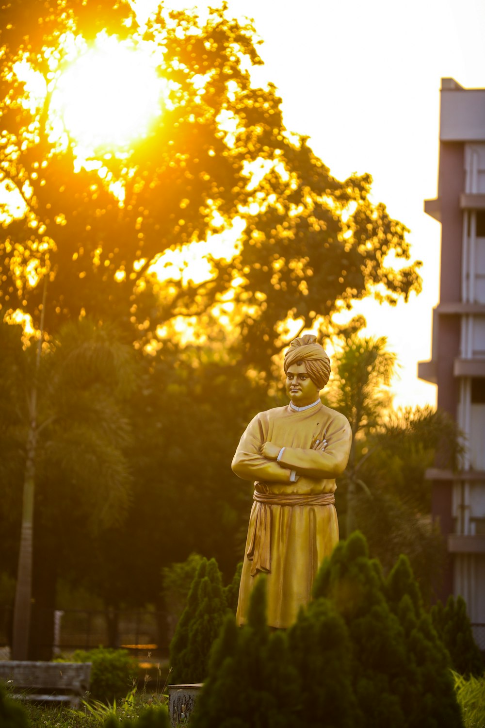 gold buddha statue near green trees during daytime