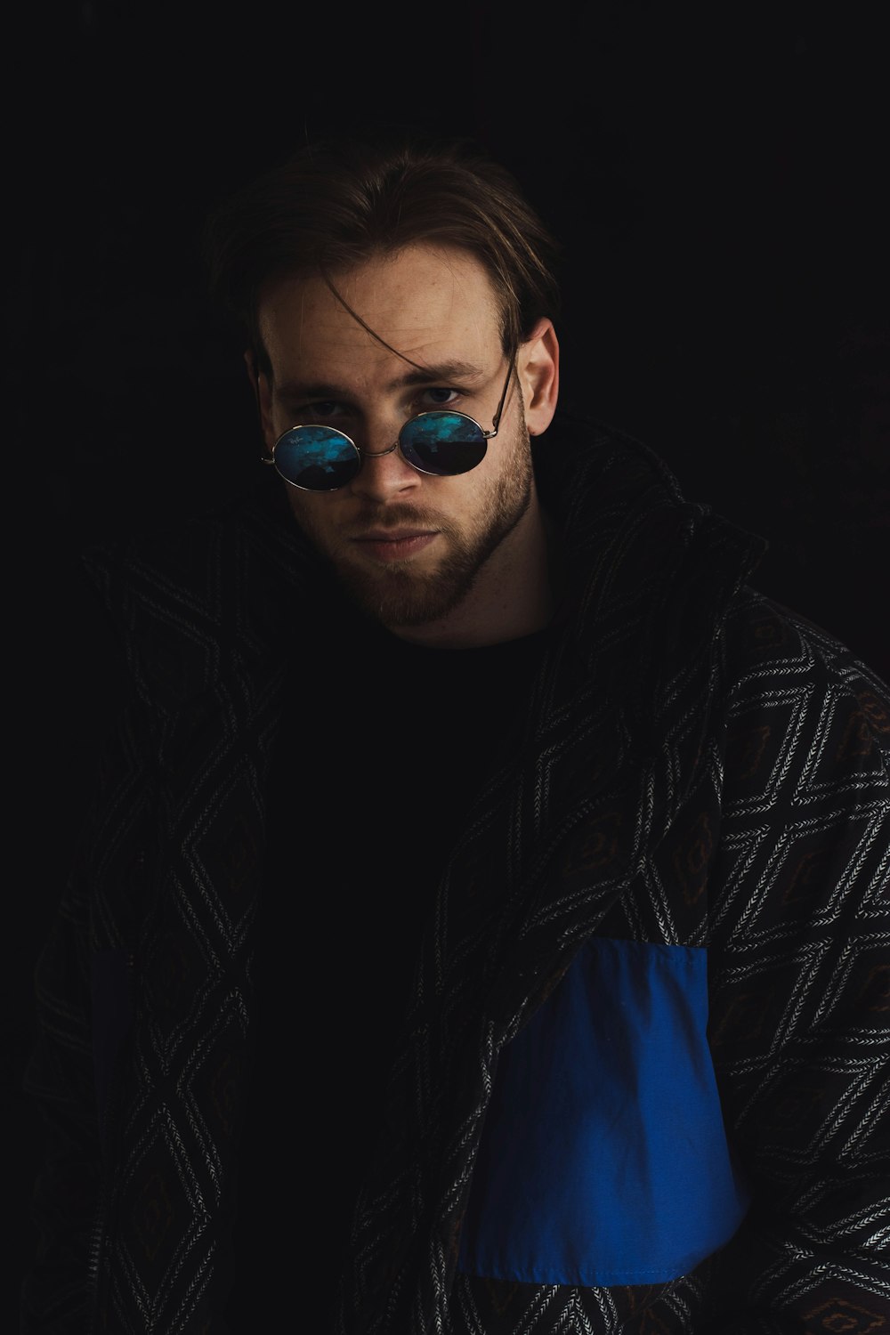 woman in black and white jacket wearing blue sunglasses