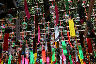 A sunlit classroom window with colorful paper decorations fluttering gently.