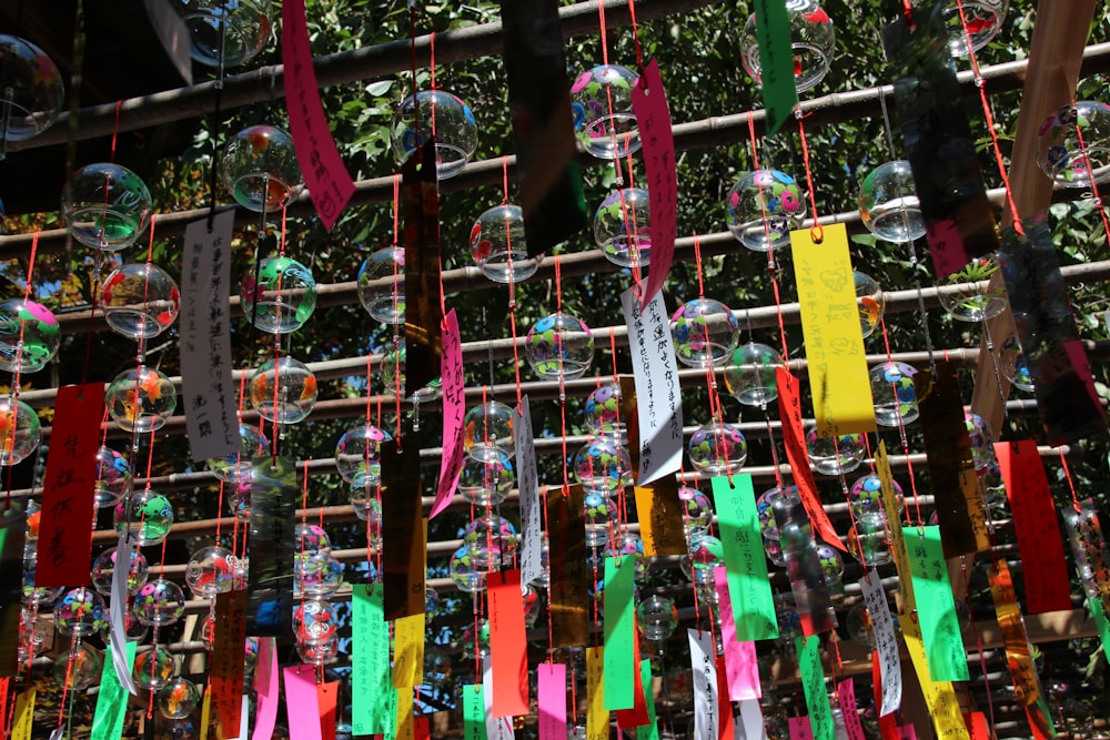 assorted color clothes hanger on green metal fence