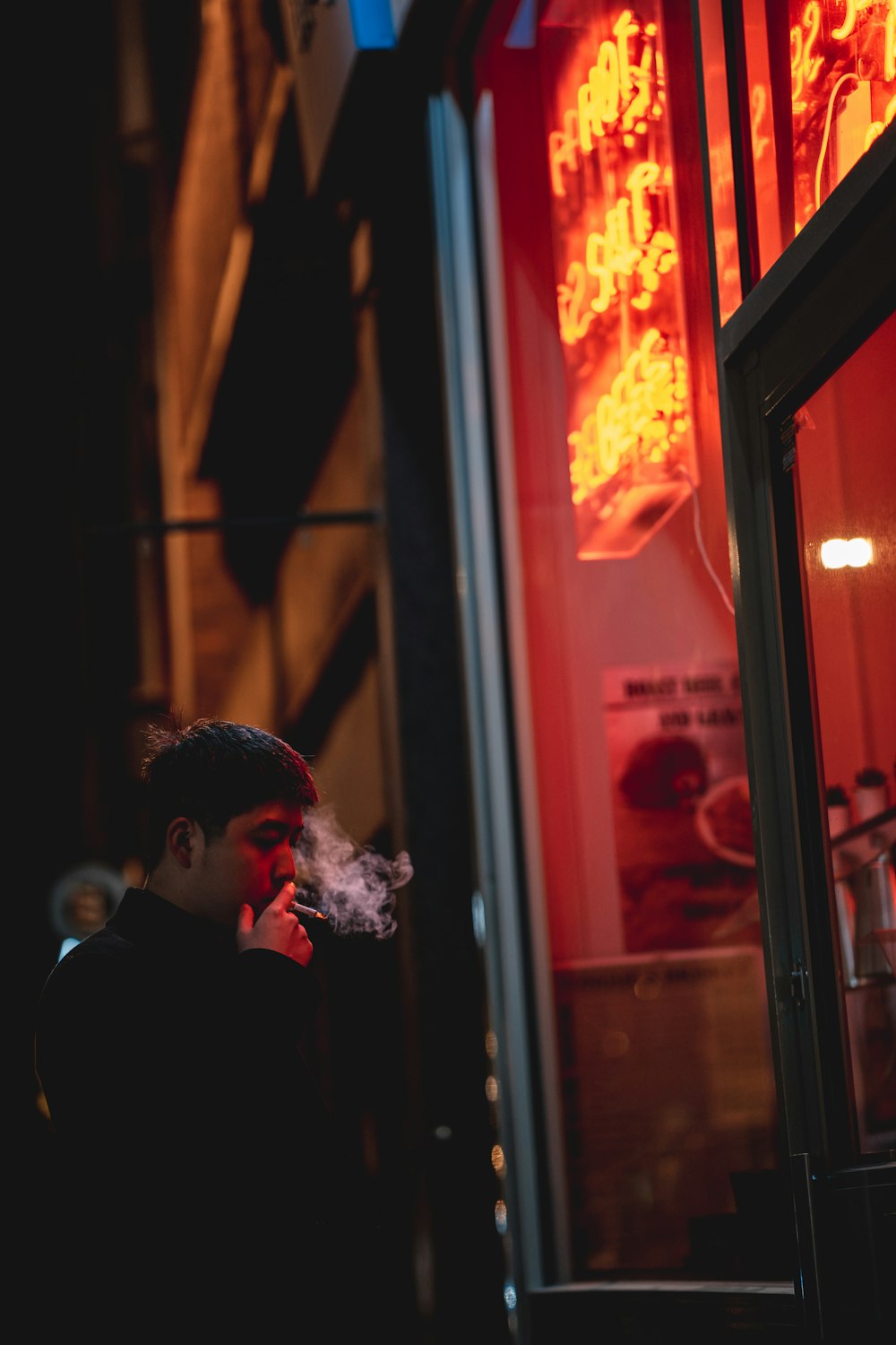 man in black suit standing near window