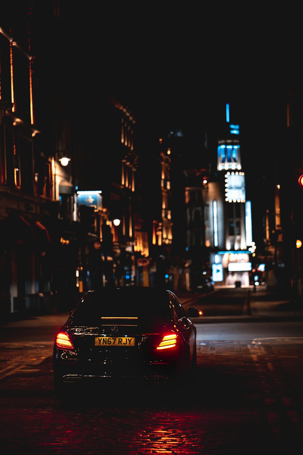 夜間の路上を走る赤い車