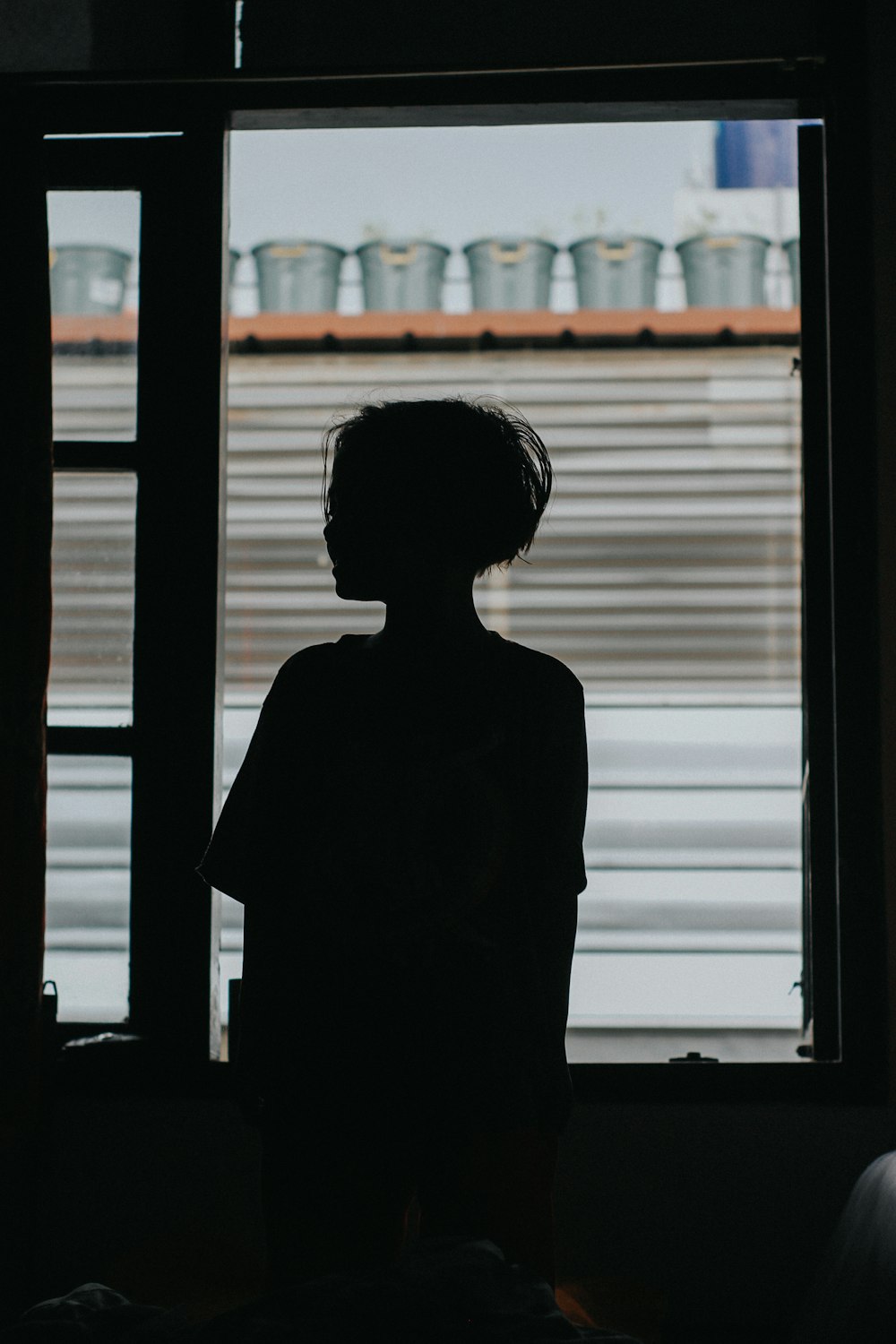 silhouette de femme debout près de la fenêtre
