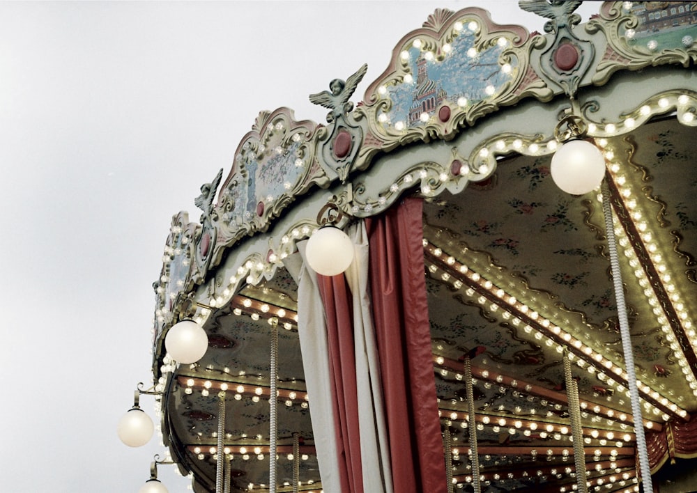 white and red carousel with lights turned on during daytime