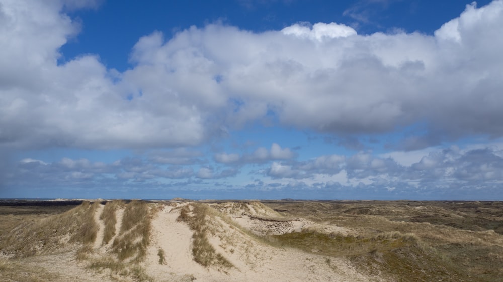 white clouds over brown field