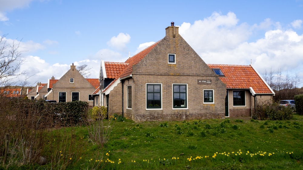 brown brick house with green grass lawn