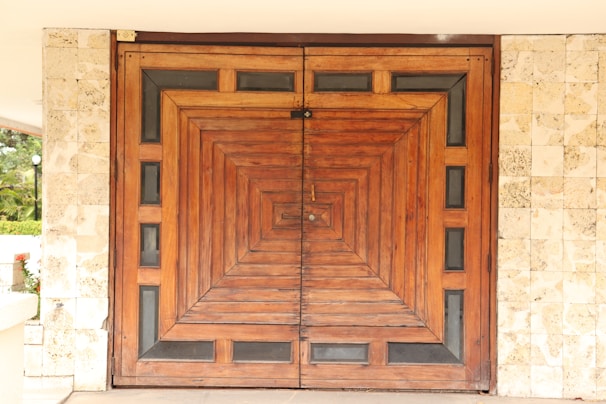 A sleek black metal door with intricate geometric patterns, installed in a modern home entrance.