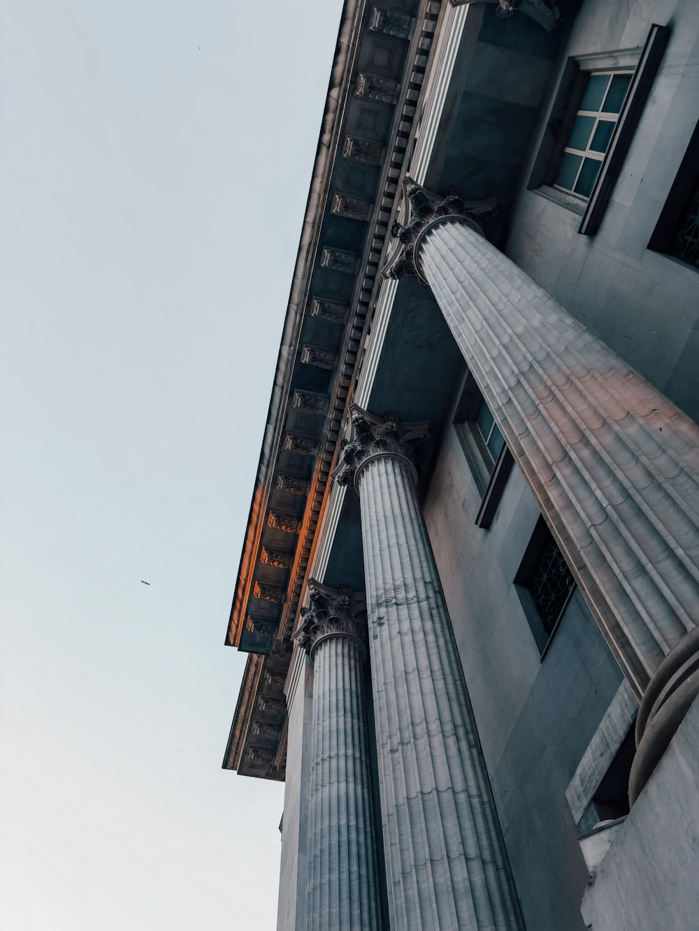 Stone columns and a carved cornice viewed from below