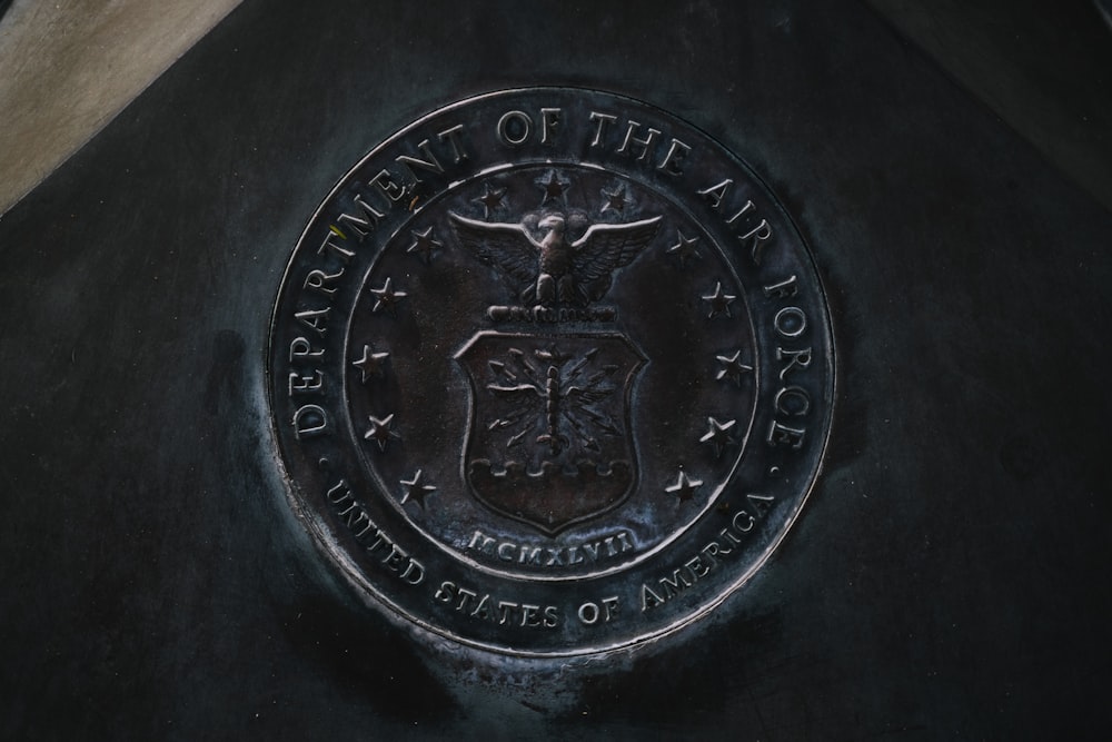 silver round coin on black textile