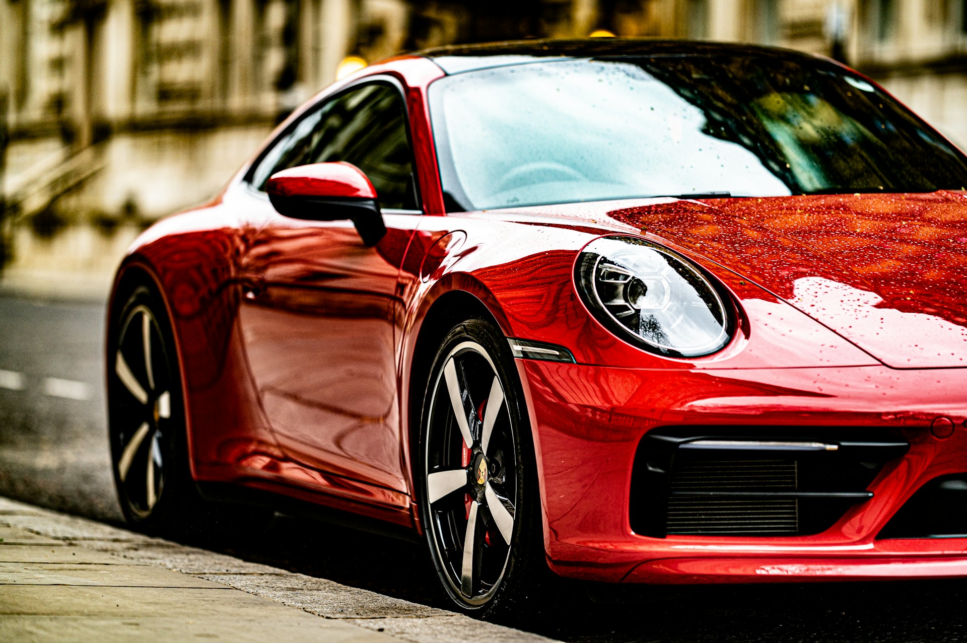 A sleek, red sports car gleaming under the city lights, showcasing its aerodynamic curves.