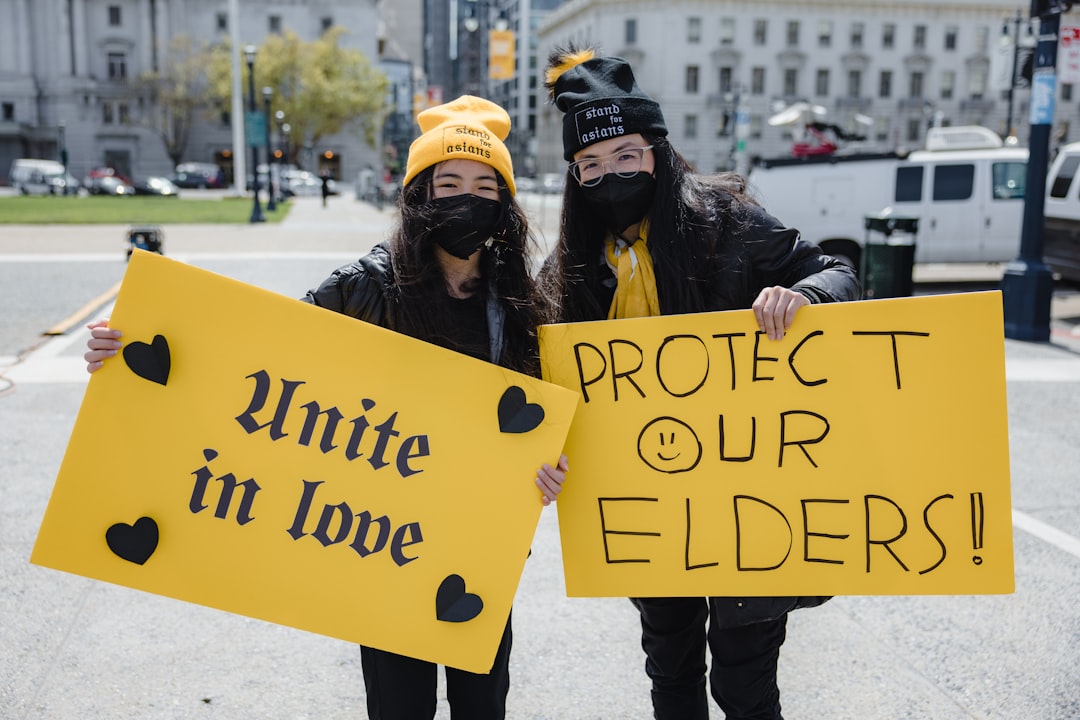 woman in black jacket holding yellow and black happy birthday signage