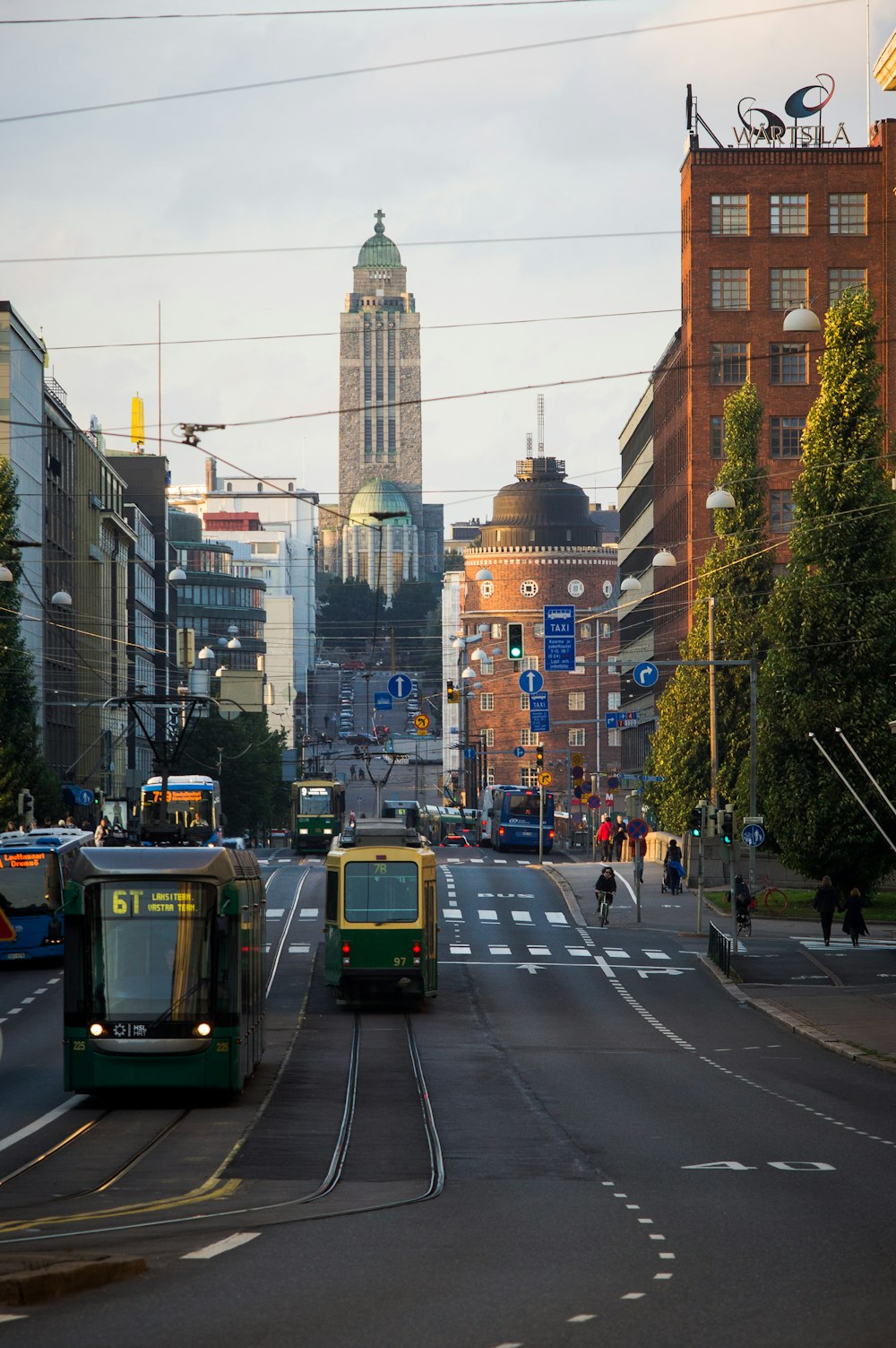 green and yellow tram on road near high rise buildings during daytime