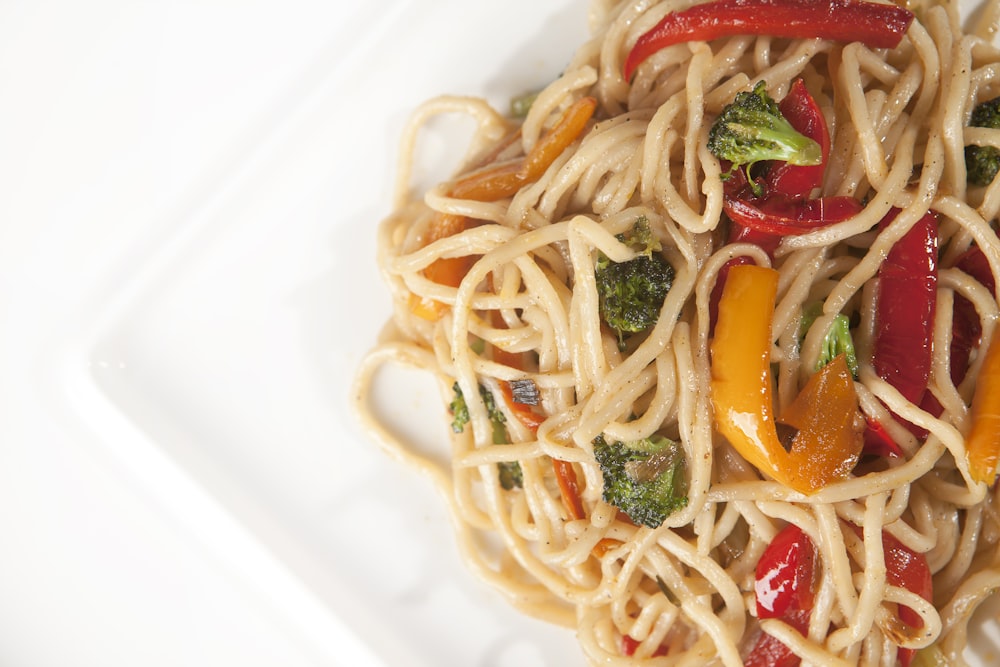 pasta with green leaf vegetable on white ceramic plate