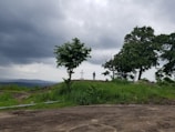 A shadowed figure standing at a crossroads under a stormy sky.