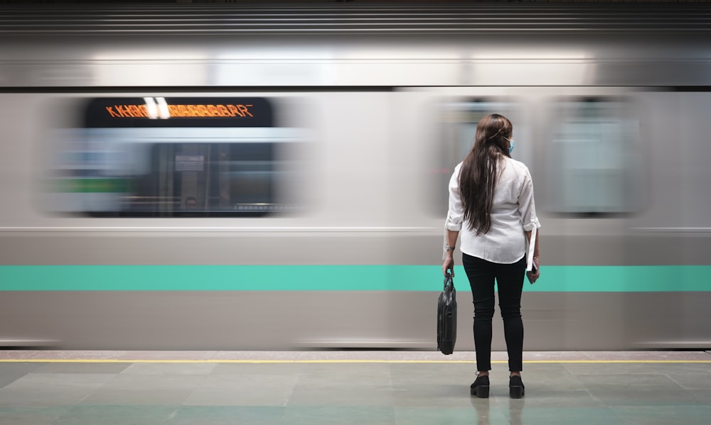 Frau in weißer Jacke neben Zug