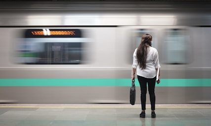 street photography,how to photograph metro; woman in white jacket standing beside train