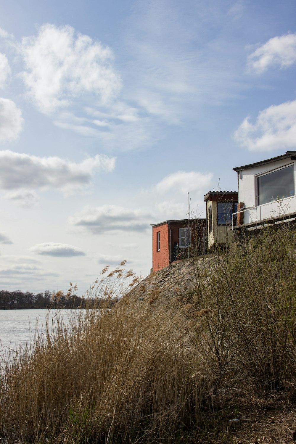 brown concrete building beside body of water under white clouds during daytime