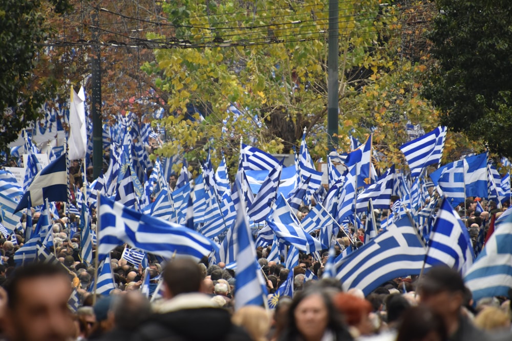 people in blue and white uniform holding flags during daytime