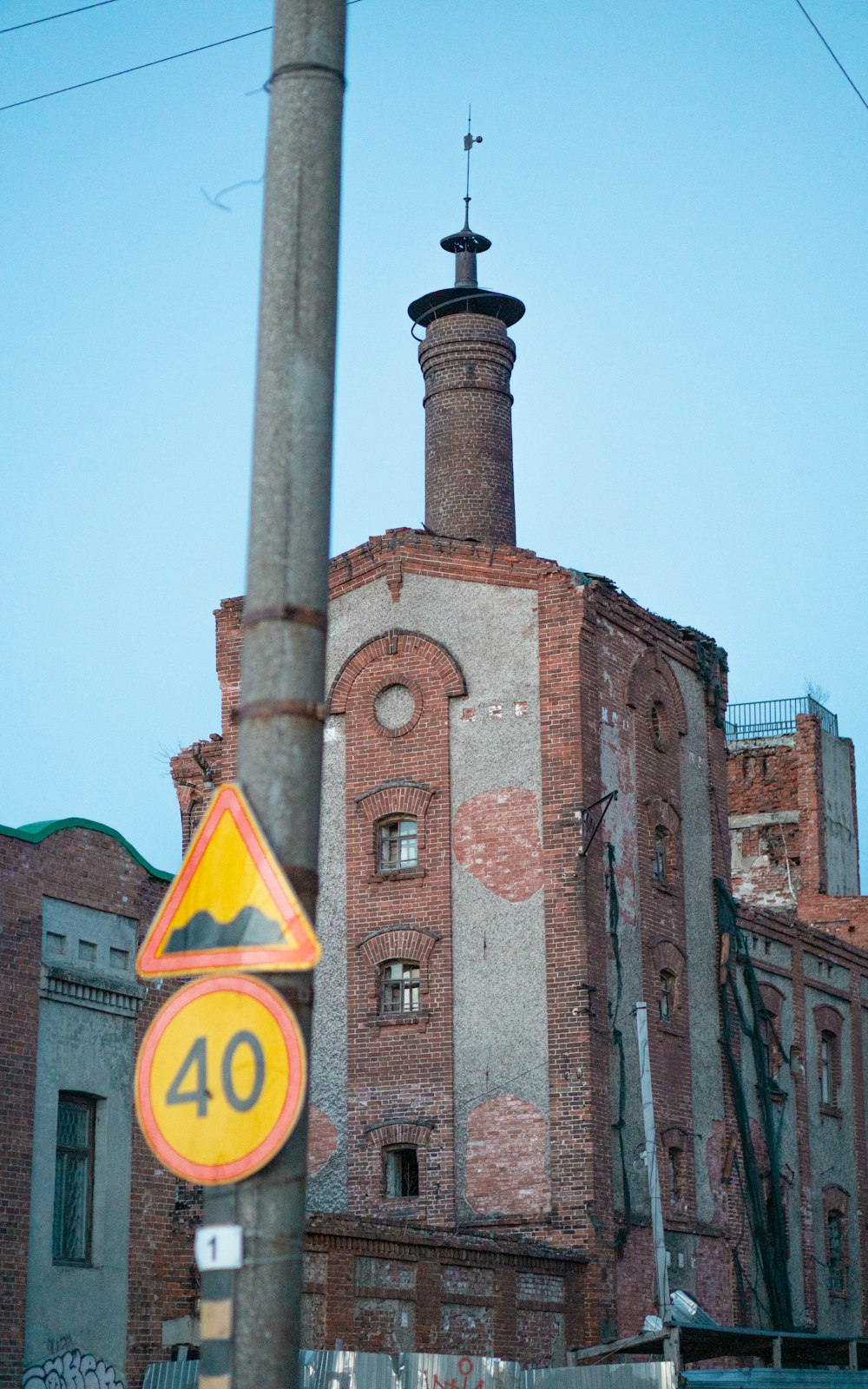 brown concrete building with yellow and black no smoking sign