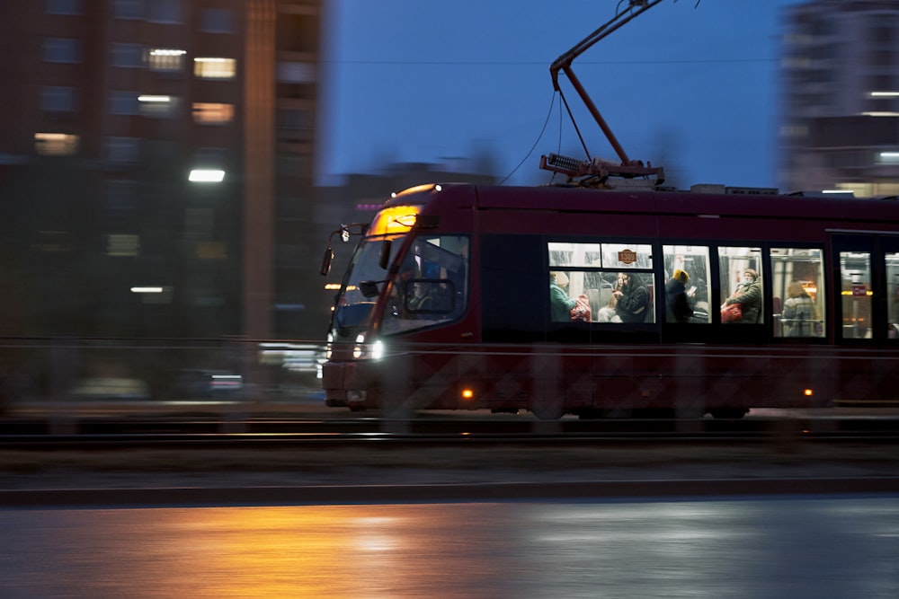 rote und schwarze Straßenbahn nachts auf der Straße