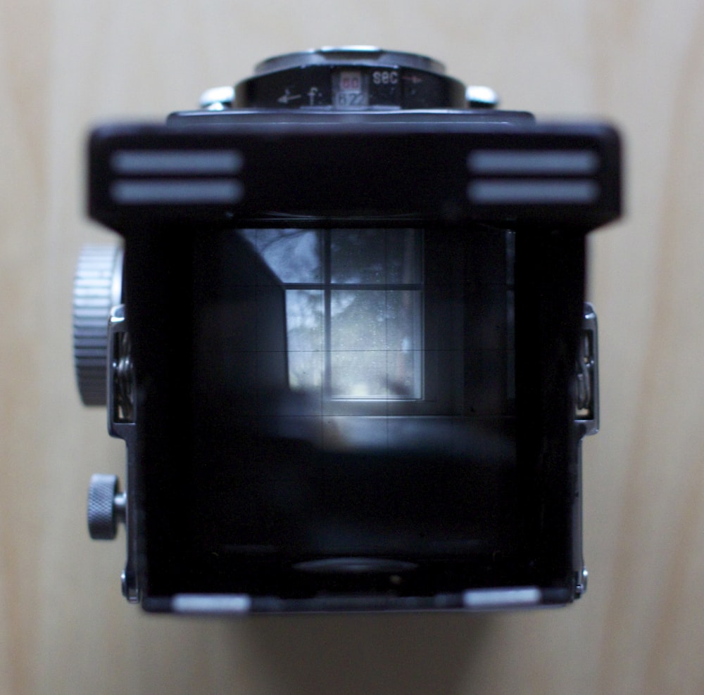 Fotocamera DSLR nera su tessuto bianco