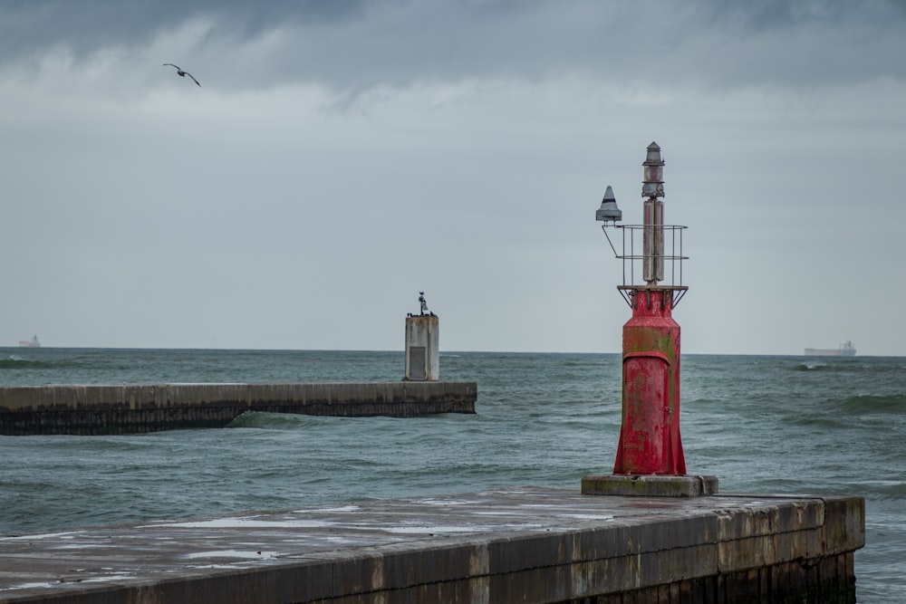 red and white lighthouse near body of water during daytime