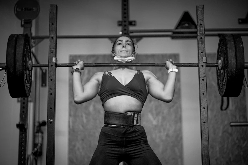 An athlete gripping a barbell during a high-intensity competition workout